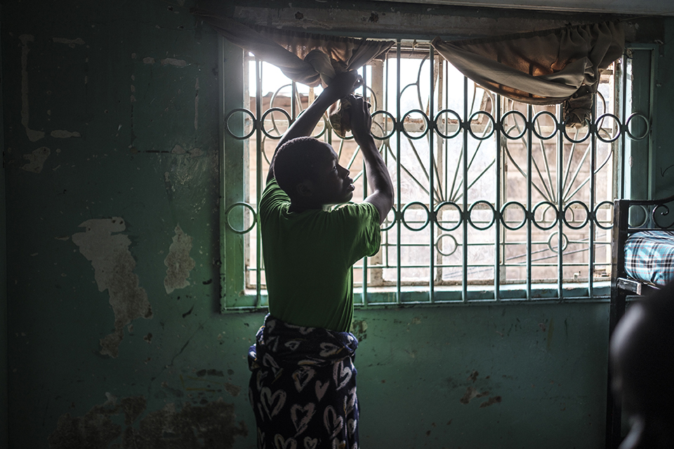 A youngsters pulls up a curtain at the Kibera Pride Children’s Home, in the city of Nairobi, Kenya, on October 27, 2023.