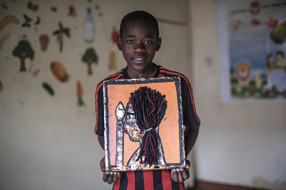 Martin Micheal holds a piece of art at the Kibera Pride Children’s Home, in the city of Nairobi, Kenya, on October 27, 2023.