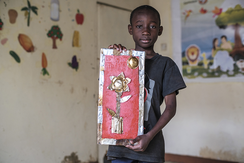 Alex Shinali holds a piece of art at the Kibera Pride Children’s Home, in the city of Nairobi, Kenya, on October 27, 2023.